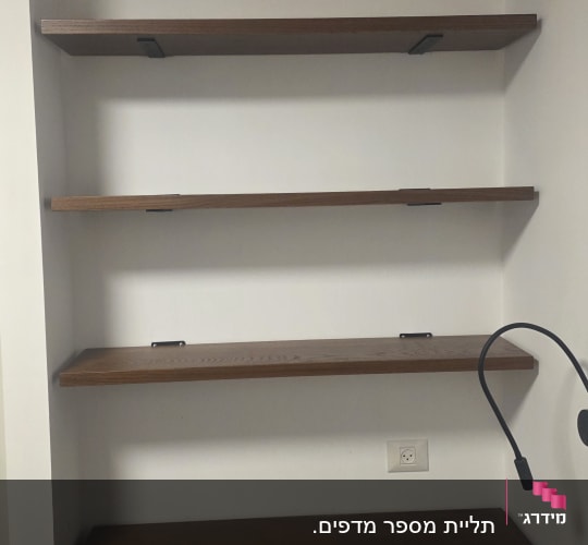 מדפים מעץ מותקנים על קיר לבן
